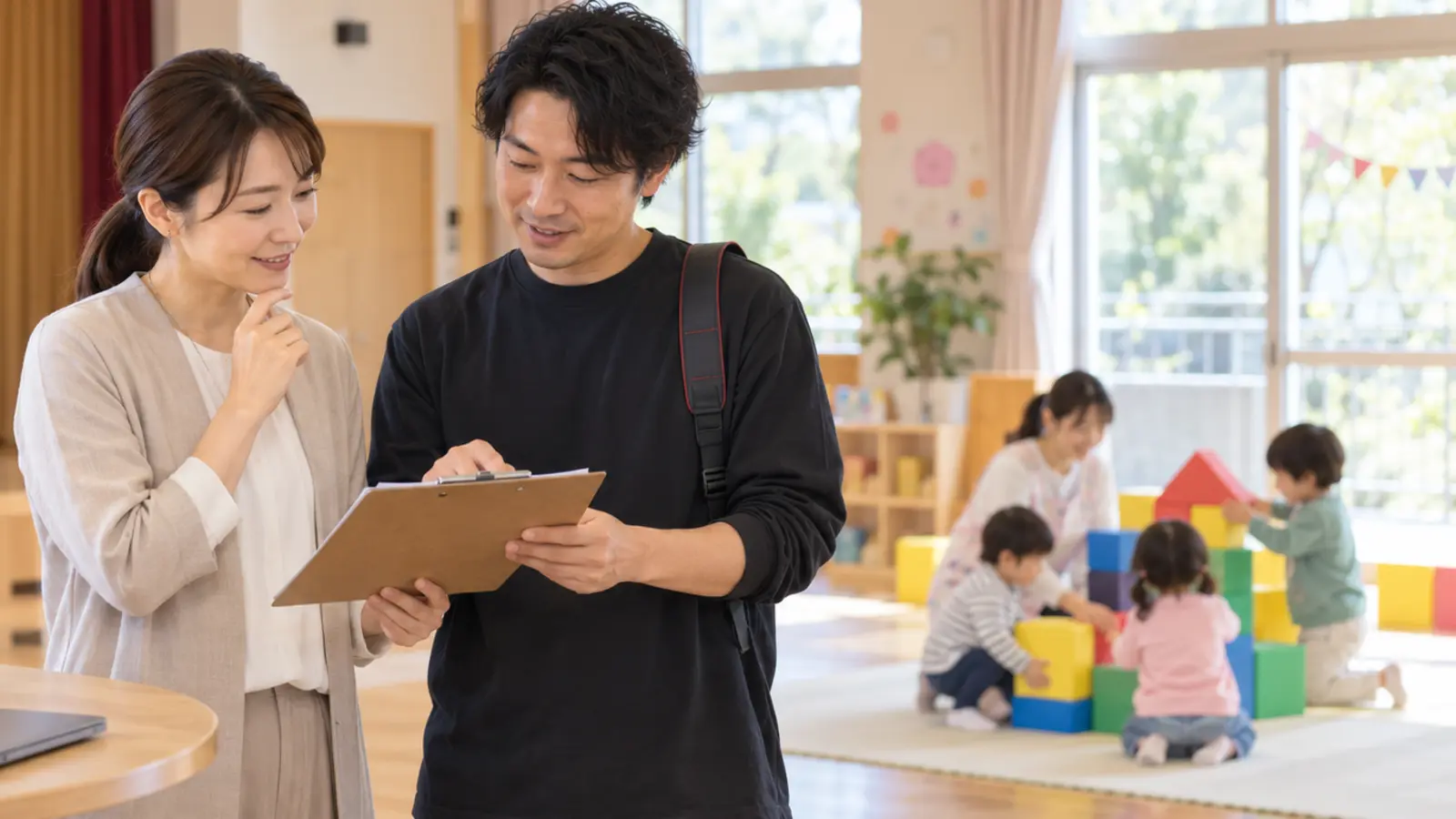 保育室で先生と撮影者が確認表を見ながら行事撮影の準備をする場面