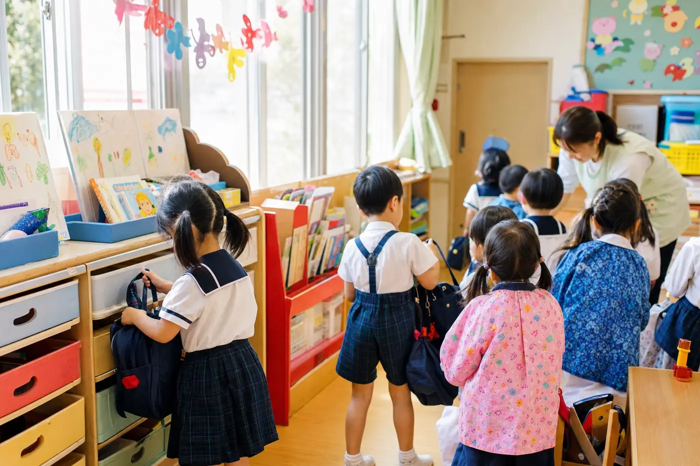 制服姿の子どもたちが明るい保育室で朝の支度をするイメージカット